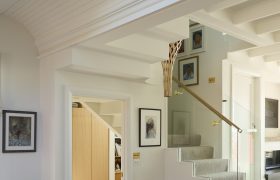 Living area looking toward the stair, where the lightwell and pendant bring soft daylight into the centre of the home.