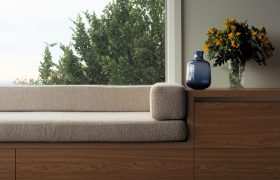 Detail of the built-in oak window seat with bouclé cushions and storage drawers below